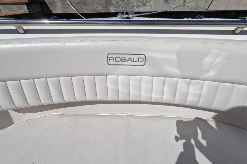 Slide: The Image of 2012 Robalo R247 Dual Console boat interior with white cushioned seating. - 76