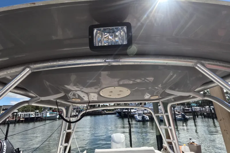 Slide: The Image of 2012 Robalo R247 Dual Console boat canopy with light, docked at marina. - 77