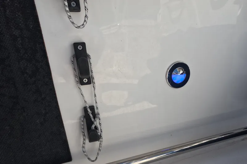 Slide: The Image of 2012 Robalo R247 Dual Console boat detail with blue LED light and rope cleats. - 78