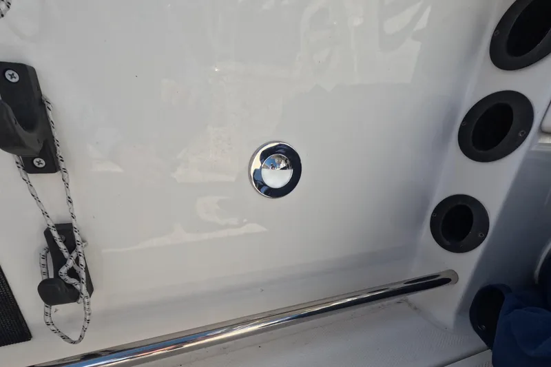 Slide: The Image of 2012 Robalo R247 Dual Console boat interior with rod holders and chrome details. - 80