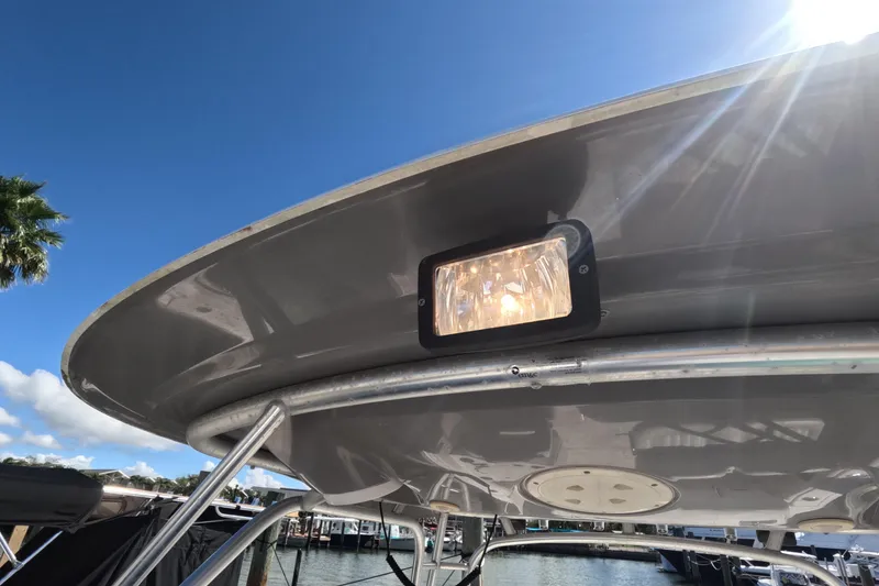 Slide: The Image of 2012 Robalo R247 Dual Console boat with spotlight, sunny marina background. - 83