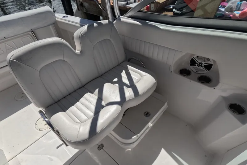 Slide: The Image of 2012 Robalo R247 Dual Console boat interior with white seating and speaker system. - 86
