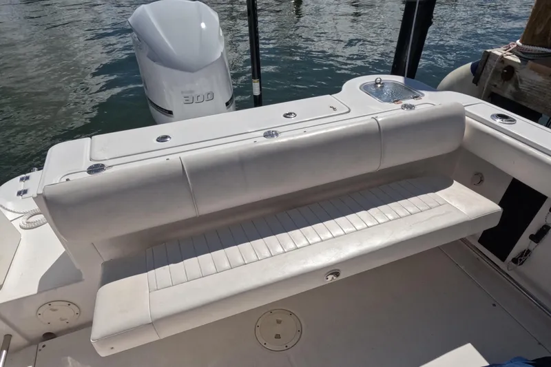 Slide: The Image of 2012 Robalo R247 Dual Console boat with cushioned seating and outboard motor. - 87