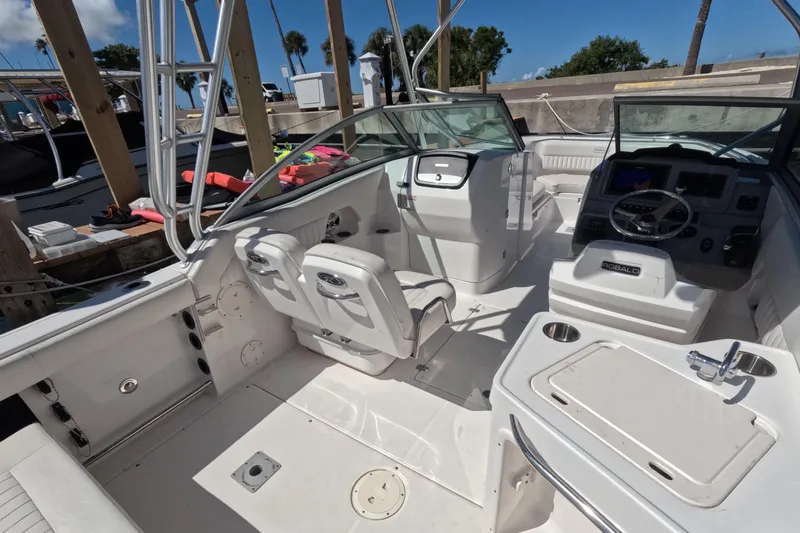 Slide: The Image of 2012 Robalo R247 Dual Console boat interior with seating and control panel at dock. - 88