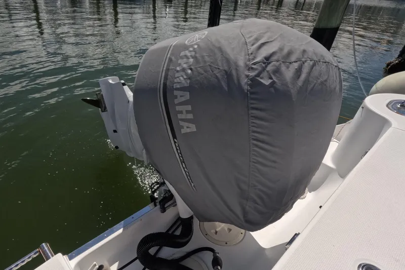 Slide: The Image of 2012 Robalo R247 Dual Console boat with covered outboard motor at marina. - 96