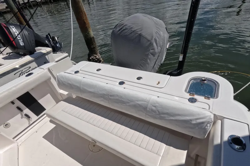Slide: The Image of 2012 Robalo R247 Dual Console with Yamaha engine cover, docked on calm water. - 97