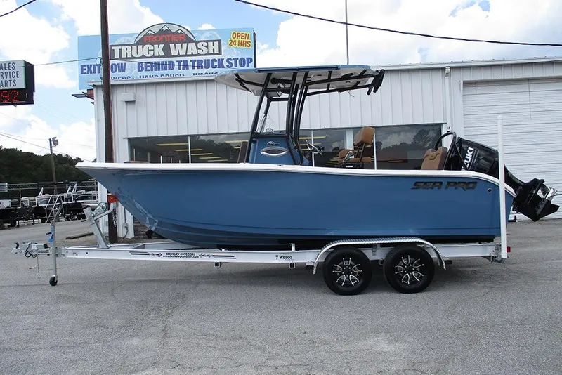 The Image of 2026 Sea Pro 225FLX Sandbar boat on trailer, parked outside a truck wash. - 0