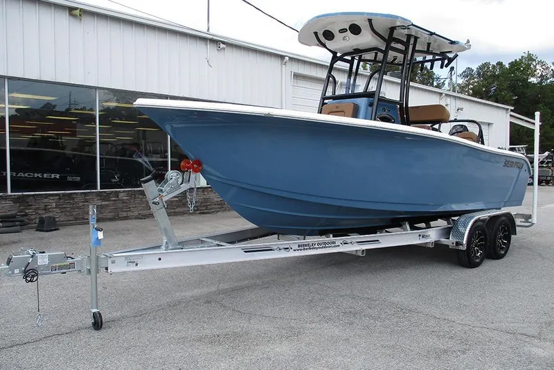 Slide: The Image of 2026 Sea Pro 225FLX Sandbar boat on trailer, parked outside a building. - 2