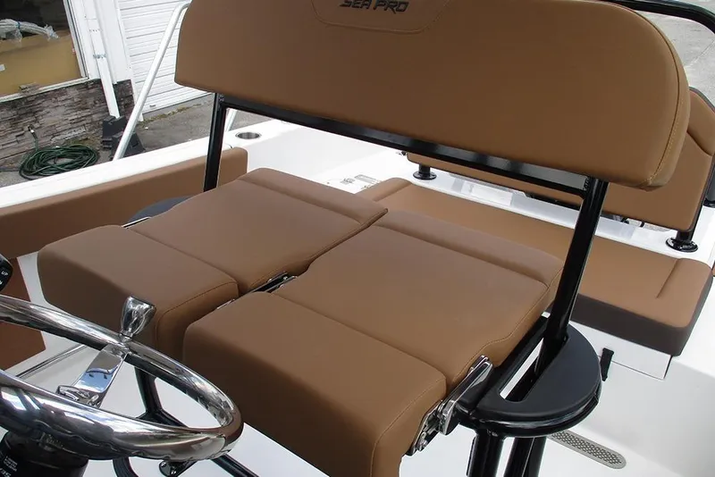 Slide: The Image of 2026 Sea Pro 225FLX Sandbar boat with brown cushioned seating and steering wheel. - 21