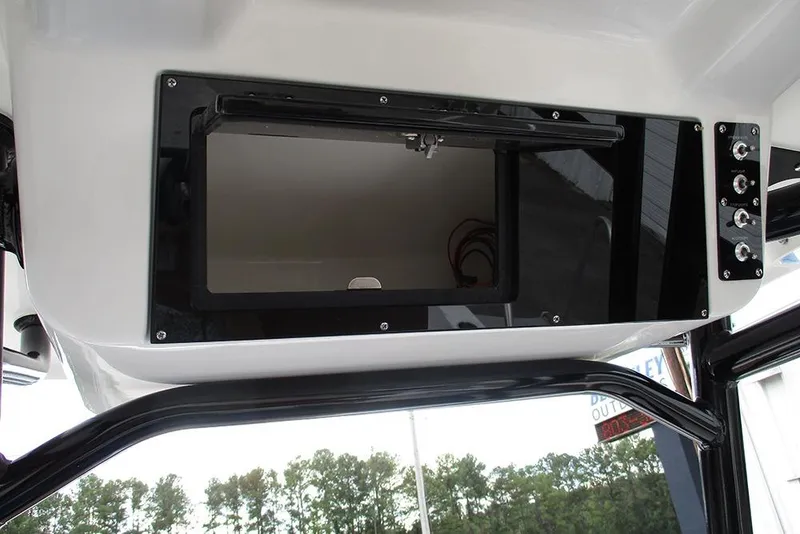 Slide: The Image of 2026 Sea Pro 225FLX Sandbar boat console storage compartment with open hatch and control panel. - 25