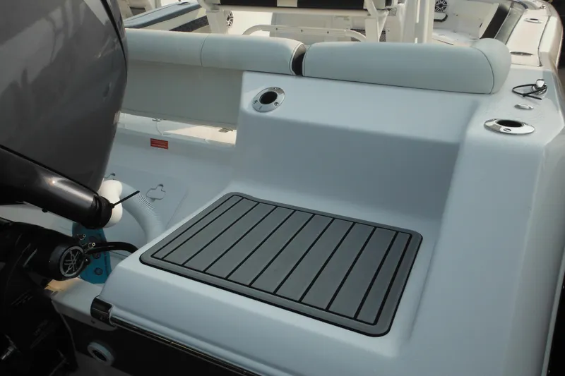 Slide: The Image of 2026 Tidewater 210 LXF boat interior with cushioned seating and motor detail. - 11