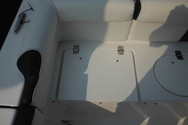 Slide: The Image of Interior seating of 2026 Tidewater 210 LXF boat, featuring white upholstery and storage compartments. - 21