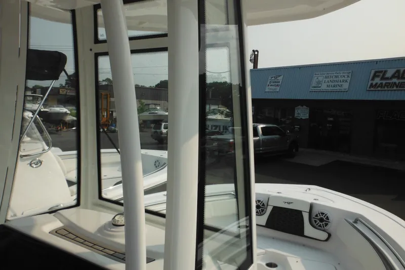 Slide: The Image of 2026 Tidewater 210 LXF boat interior with view of marine dealership exterior. - 52