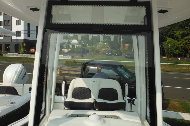 Slide: The Image of 2026 Tidewater 210 LXF boat interior with Yamaha engine, parked near a road. - 62