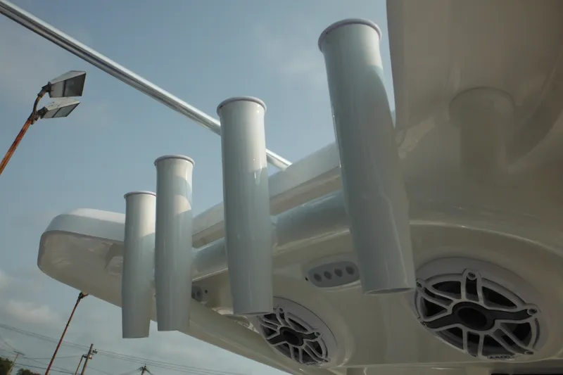 Slide: The Image of 2026 Tidewater 210 LXF boat rod holders and speakers under clear sky. - 65