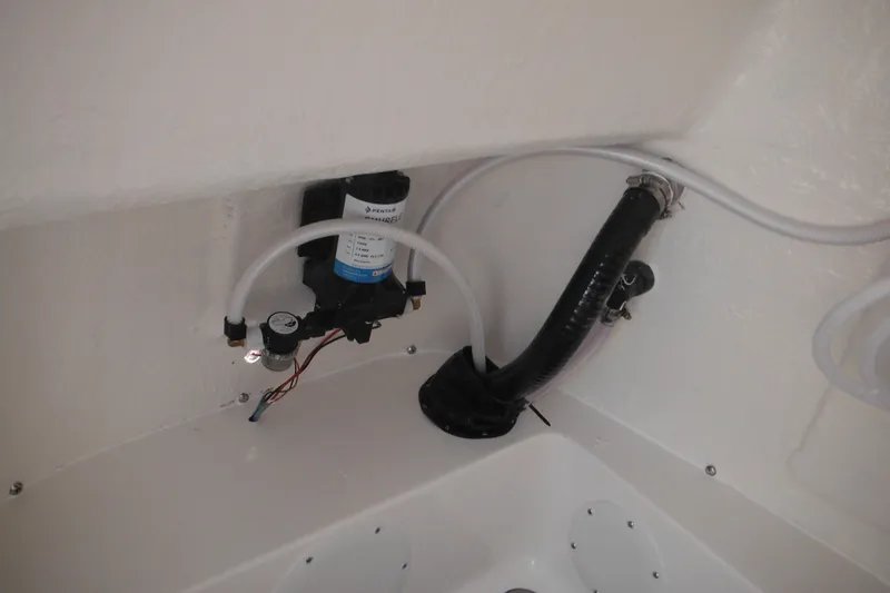 Slide: The Image of 2026 Tidewater 210 LXF boat interior plumbing system with hoses and pump. - 78