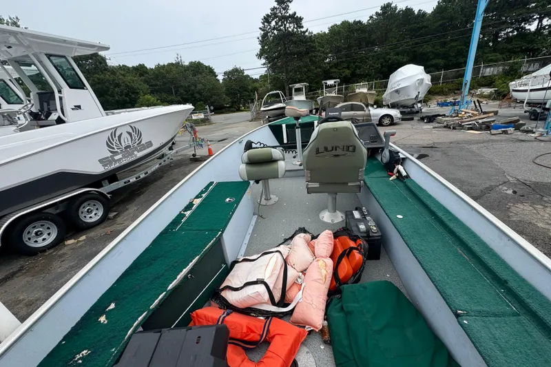 Slide: The Image of 2005 Lund 1675 Adventure SS boat with green interior, life jackets, and equipment on deck. - 3