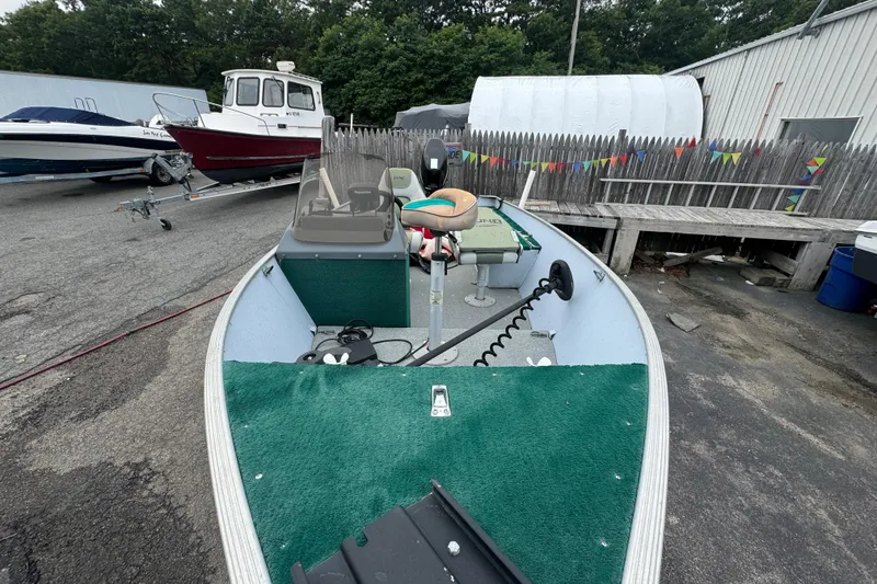 Slide: The Image of 2005 Lund 1675 Adventure SS boat with green interior, parked outdoors. - 4