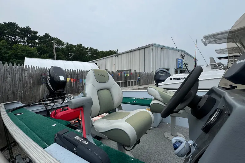 Slide: The Image of 2005 Lund 1675 Adventure SS boat with seating and steering wheel, parked outdoors. - 6