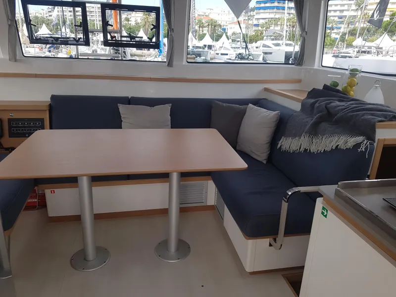 Slide: The Image of Cozy interior of 2020 Excess 12 yacht with blue seating and wooden table. - 3