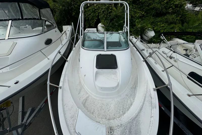 Slide: The Image of 1999 Bayliner 2102 Trophy boat docked among other vessels, top view. - 4