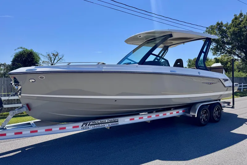 The Image of 2026 Monterey Elite 27 OB boat on trailer, sleek design, sunny day. - 1