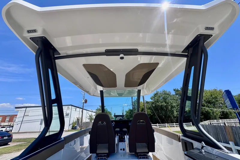 Slide: The Image of 2026 Monterey Elite 27 OB boat interior with sleek design and modern features under a clear blue sky. - 12