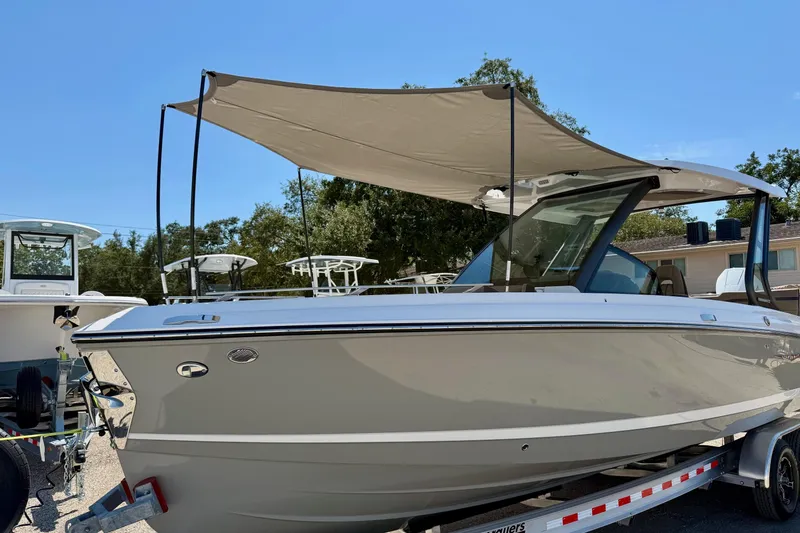 Slide: The Image of 2026 Monterey Elite 27 OB boat with canopy on trailer, parked outdoors. - 21