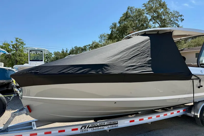 Slide: The Image of 2026 Monterey Elite 27 OB boat covered on a trailer under a clear blue sky. - 22