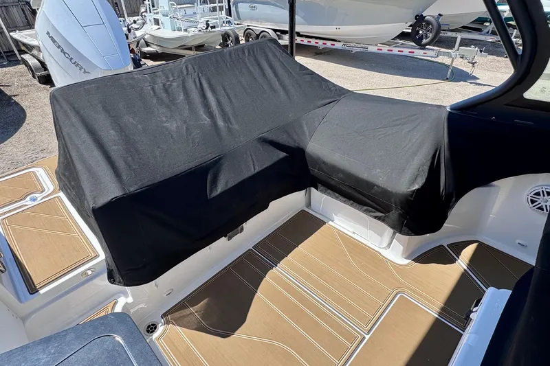 Slide: The Image of 2026 Monterey Elite 27 OB boat interior with covered seating and teak-style flooring. - 25