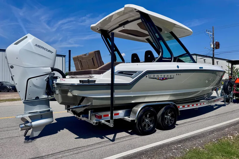 Slide: The Image of 2026 Monterey Elite 27 OB boat on trailer, featuring Mercury outboard motor, parked on street. - 4
