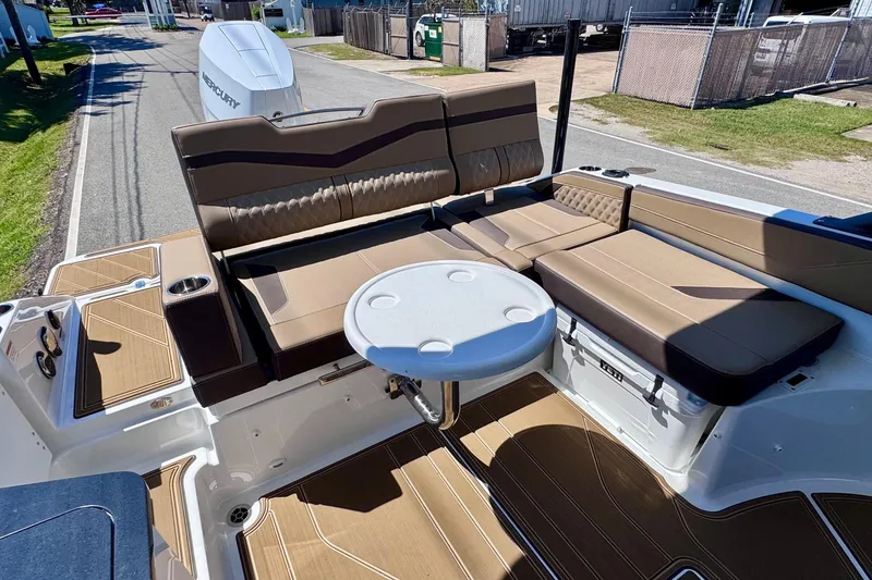 Slide: The Image of 2026 Monterey Elite 27 OB boat interior with brown seating and round table. - 7