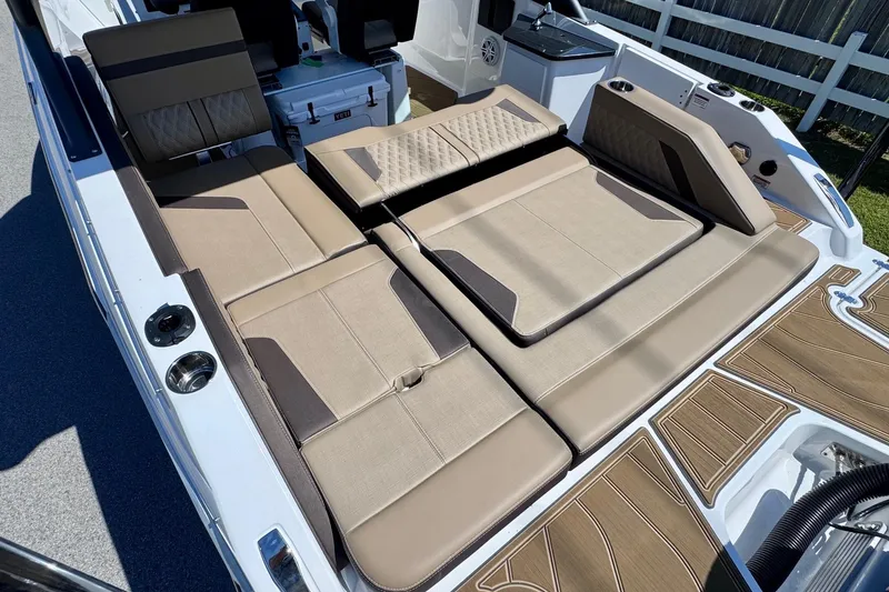 Slide: The Image of 2026 Monterey Elite 27 OB boat interior with beige seating and wood-patterned flooring. - 9