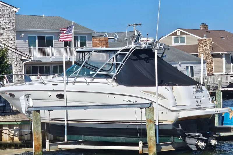 Slide: The Image of 2000 Sea Ray 290 Amberjack boat docked near waterfront homes. - 2