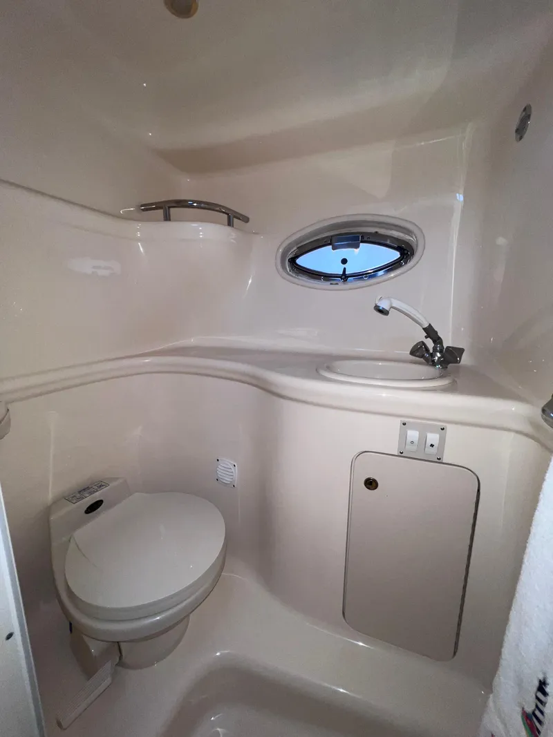 Slide: The Image of 2000 Sea Ray 290 Amberjack boat bathroom with toilet, sink, and porthole window. - 20