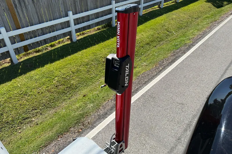 Slide: The Image of Red Minn Kota Talon anchor mounted on a vehicle, near a white fence and grassy area. - 17