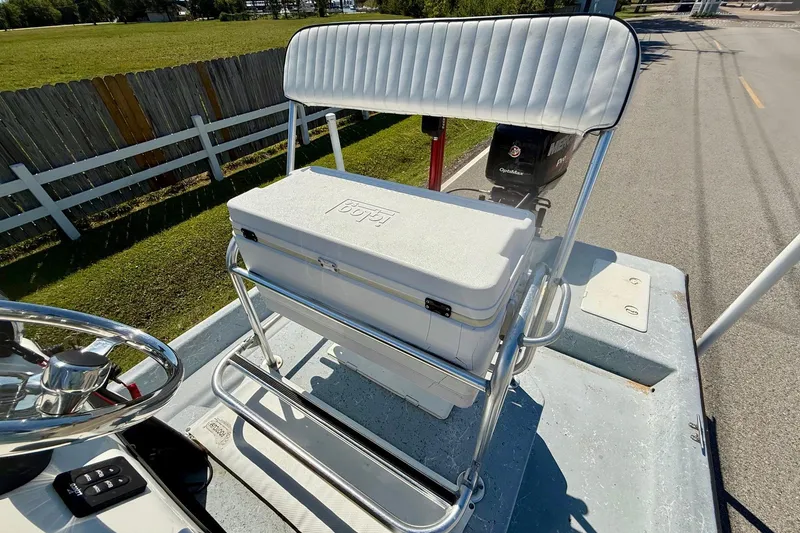 Slide: The Image of 2004 Destiny 190 TV boat with white seating and cooler on deck. - 9