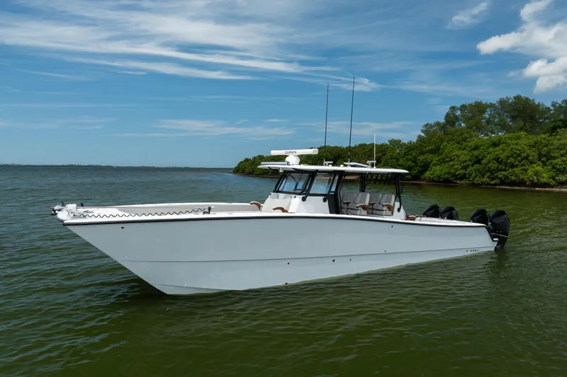 Slide: The Image of 2025 Freeman 42 LR boat on calm water, clear sky, lush green shoreline. - 11