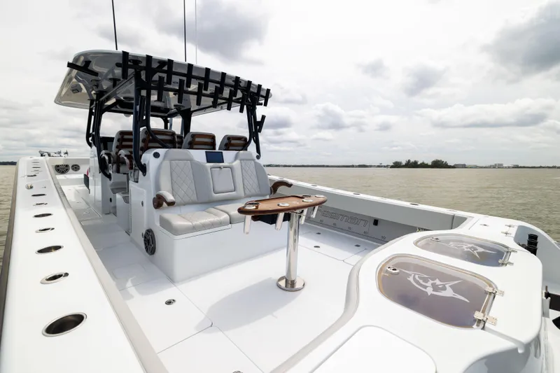 Slide: The Image of 2025 Freeman 42 LR boat with luxurious seating and fishing rod holders on a calm water backdrop. - 25
