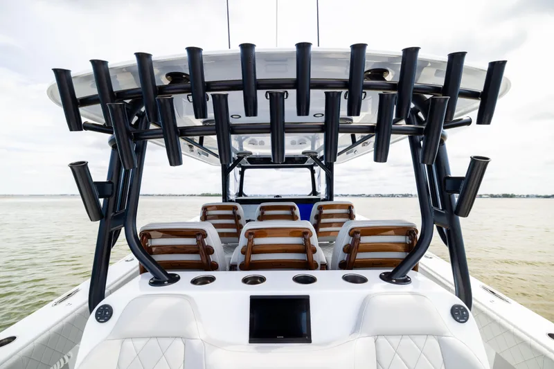 Slide: The Image of 2025 Freeman 42 LR boat interior with rod holders and seating on calm water. - 30