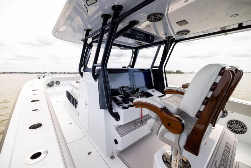 Slide: The Image of 2025 Freeman 42 LR boat cockpit with modern controls and luxurious seating on open water. - 40