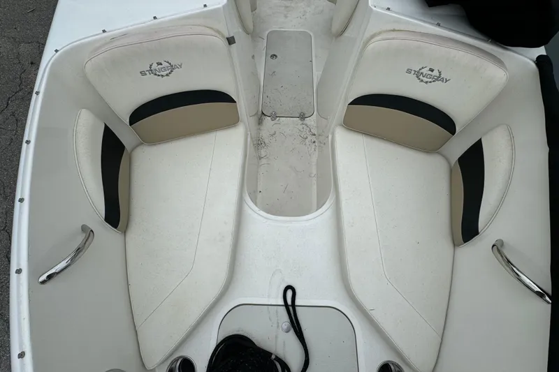 Slide: The Image of 2016 Stingray 198 RX boat interior with white and beige seating, featuring Stingray logo. - 10