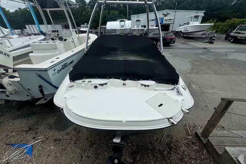 Slide: The Image of 2016 Stingray 198 RX boat with black cover in a marina setting. - 3