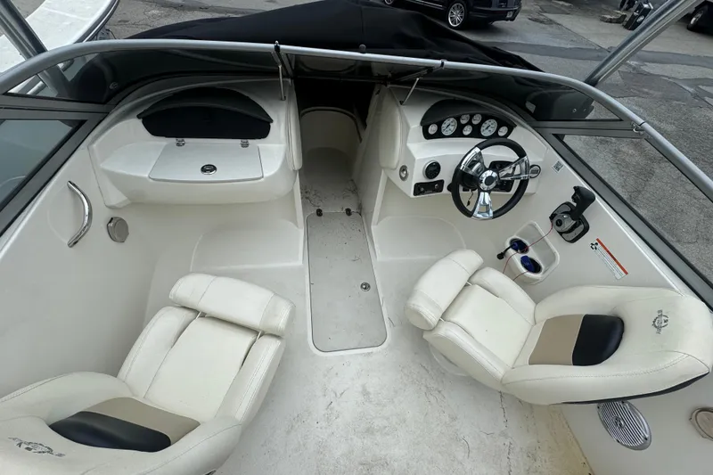 Slide: The Image of 2016 Stingray 198 RX boat interior with white seating and modern dashboard controls. - 7
