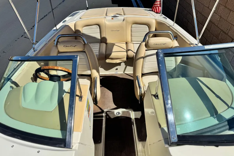 Slide: The Image of 2013 Chris-Craft Launch 22 boat interior with beige seating and wooden steering wheel. - 15