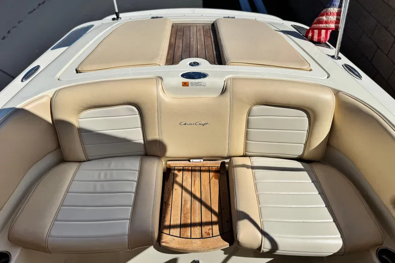Slide: The Image of 2013 Chris-Craft Launch 22 boat interior with beige leather seats and wooden flooring. - 17