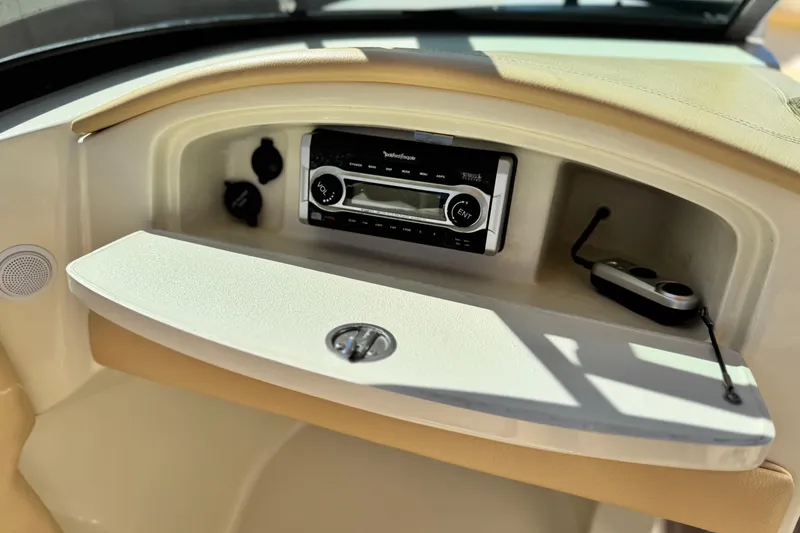 Slide: The Image of 2013 Chris-Craft Launch 22 dashboard with stereo system and storage compartment. - 23