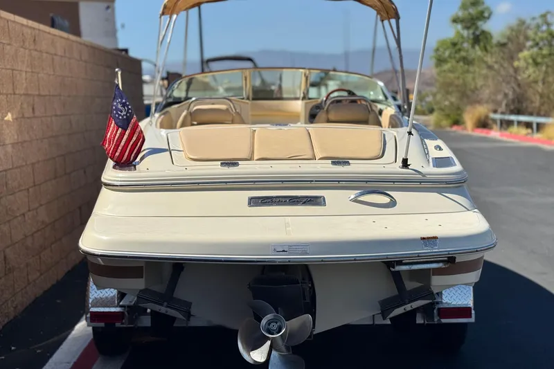 Slide: The Image of 2013 Chris-Craft Launch 22 boat with American flag, parked outdoors. - 4