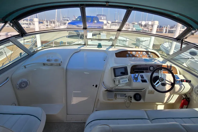 Slide: The Image of 1995 Sea Ray 330 Sundancer cockpit with steering wheel, gauges, and navigation equipment. - 13