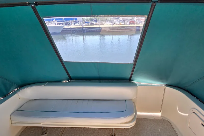 Slide: The Image of 1995 Sea Ray 330 Sundancer interior with teal canopy and waterfront view. - 18